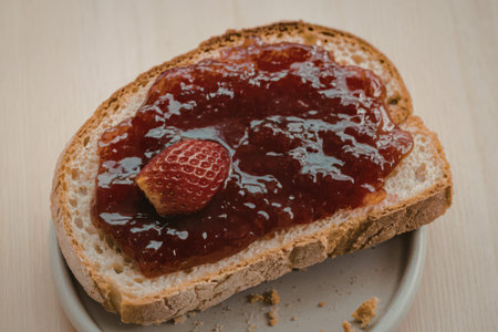 A photo of a slice of bread spread with jam