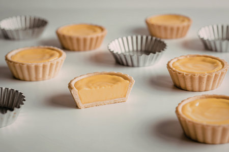 multiple small golden-yellow custard tarts
