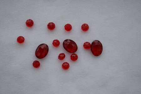 Red beads of different sizes on a white background. Goods for creativity and needlework.の写真素材