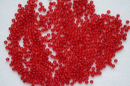 Red beads on a white background. Goods for creativity and needlework.の写真素材