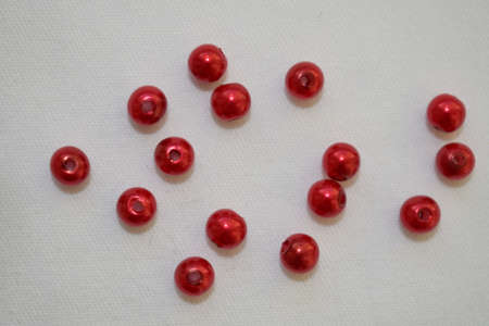 Red round beads on a white background. Goods for creativity and needlework.の写真素材