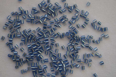 Blue cylindrical beads on a white background. Goods for creativity and needlework.の写真素材