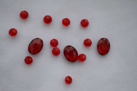 Red beads of different sizes on a white background. Goods for creativity and needlework.の写真素材