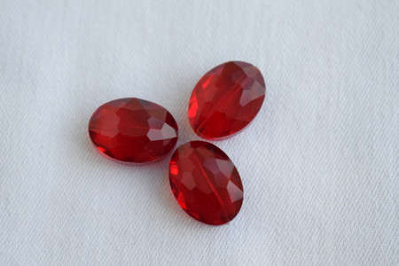Large red oval beads on a white background. Goods for creativity and needlework.の写真素材