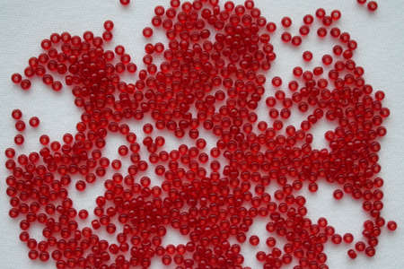Red beads on a white background. Goods for creativity and needlework.の写真素材