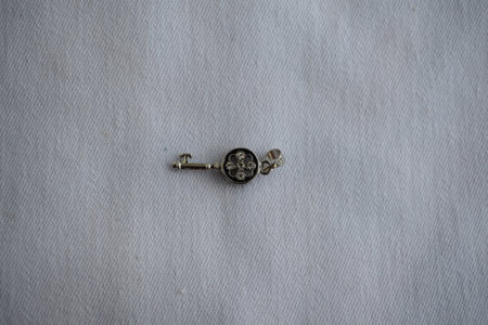 Silver hanging key on a white background. Goods for creativity and needlework.の写真素材
