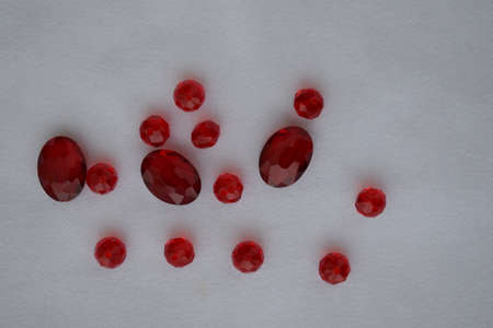 Red beads of different sizes on a white background. Goods for creativity and needlework.の写真素材