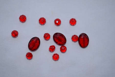 Red beads of different sizes on a white background. Goods for creativity and needlework.の写真素材