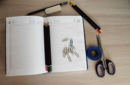 Stationery. Notepad, pencils, paper clips, scissors and an eraser on a white background. The view from the top.の写真素材