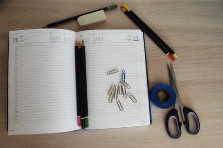 Stationery. Notepad, pencils, paper clips, scissors and an eraser on a white background. The view from the top.の写真素材