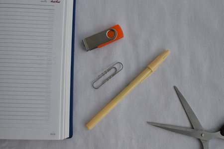 Stationery. Paper clip, scissors, pen, notepad and flash drive on a white background. The view from the top.の写真素材
