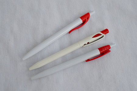 Stationery. Three red and white pens on a white background. The view from the top.の写真素材