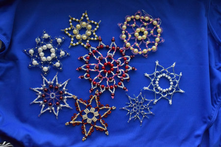 Beautiful snowflakes made of beads on a blue background. Handmade.の写真素材