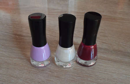 Bottles of nail polish on a wooden table. The view from the top.の写真素材