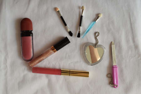 Makeup cosmetics on a blue background. The view from the top. Lipstick, mirror, brushes, nail file.の写真素材