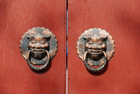 copper lion knocker on red doorの写真素材