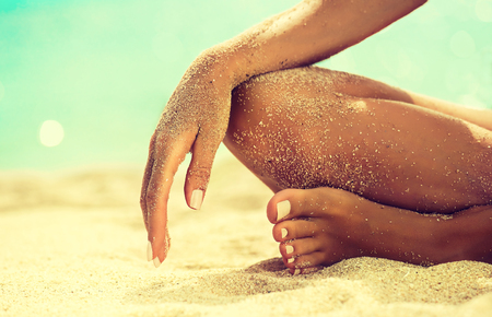 Body parts, Womans hand laying on the knee. Image of rest and relaxation on tropical beach.  Tanned girl in Lotus position yoga and meditation.の写真素材