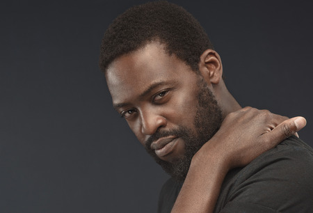 Portrait of middle-aged bearded handsome man. Black male beauty concept. Straight, contemplative and thoughtful look at the viewer.の写真素材