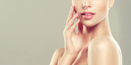 Graceful gesture of elegant hand in front of beautiful rose lips. Closeup detail.  Fashion makeup and cosmetology.の写真素材