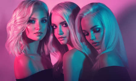 Triple portrait of young attractive models with faces shaded in a different colors. Palette tints of light on the faces of attractive blond haired models. Sensual looks and elegant hairstyles. Coloratの写真素材