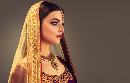 Portrait of beautiful,black eyed woman dressed in a traditional indian blouse, shawl (dupatta) and bright jewelry set.Indian beauty.の写真素材
