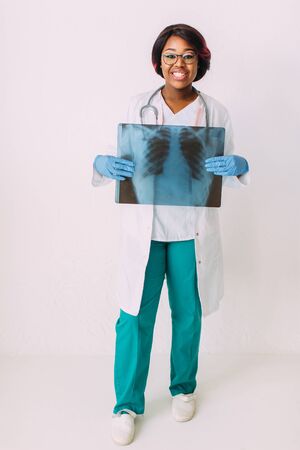 Young smiling African American woman doctor in medical clothes holding patients x-rayの写真素材