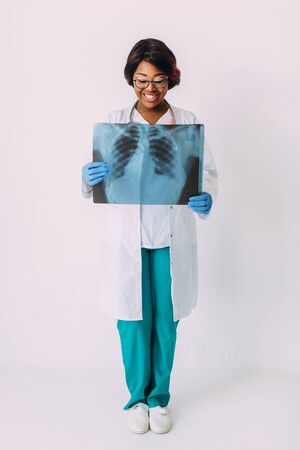 Young smiling African American woman doctor in medical clothes holding patients x-rayの写真素材