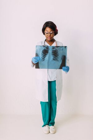 Young smiling African American woman doctor in medical clothes holding patients x-rayの写真素材