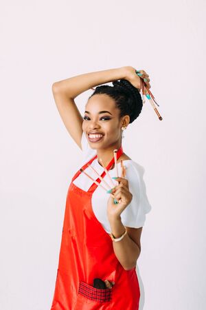 Beautiful young African American beautician woman holding set of make up brushes.の写真素材