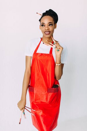 Beautiful young African American beautician woman holding set of make up brushes.の写真素材
