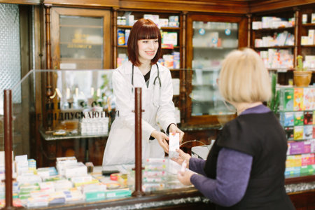 Pharmacist explaining medicine to his customer in the pharmacy.の写真素材