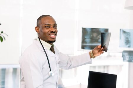 Portrait of a doctor looking at a radiography. African-American black smiling doctor man in the hospitalの写真素材