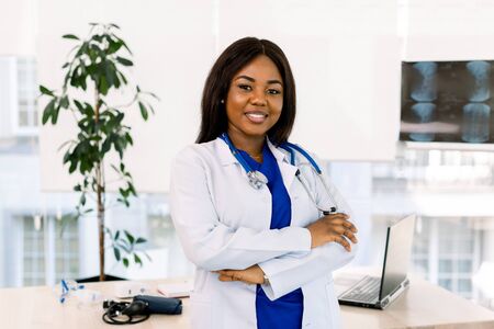 Portrait Of Female Doctor In Doctors Office. Successful African woman doctor standing in officeの写真素材