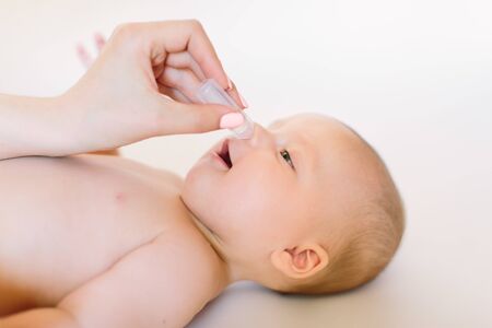 Newborn baby gets nose drops. Baby care conceptの写真素材