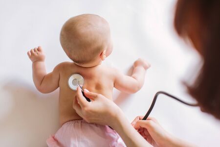 Doctor Using A Stethoscope To Listen To Baby's back , Baby Health Concep.の写真素材