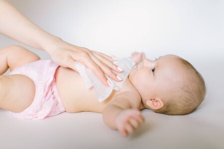 Hygiene - young momy wiping the baby skin with wet wipes. Cleaning wipe, pure, clean.の写真素材