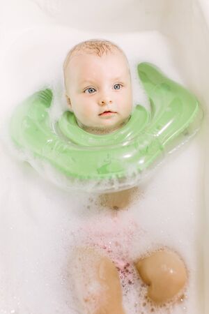 Baby swimming with green neck swim ring.の写真素材
