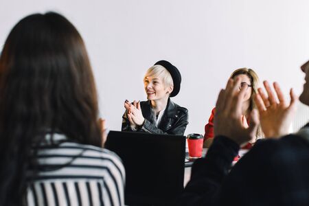 Creative agency meeting - group of business people in casual wear talking during conference at office and applauding during speech.の写真素材