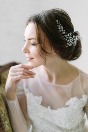 Beauty portrait of a bride with exquisite decoration in her hair, studio indoor photo.