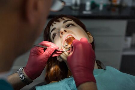 Young female patient takes a dental attendance in the dentist's office.の写真素材