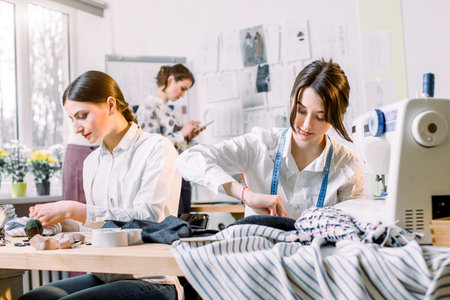 Portrait of young fashion dressmakers women at work. Dressmaker, tailor, fashion and showroom...