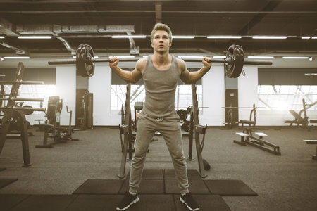 Fit and ripped man lifting weights in the gym. Gym lifestyle concept.の写真素材