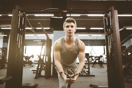 fitness and bodybuilding concept. Strong and handsome athletic young man with muscles abs and biceps training in the gym. Close-up of a power fitness manの写真素材