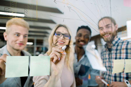 Business, startup, planning and people concept. Pretty blond woman in eyeglasses drawing chart...
