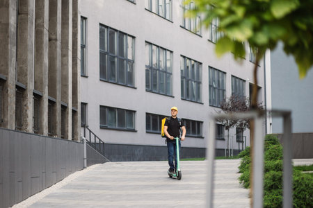 Man courier on scooter in town streets with a hot food delivery from takeaways and restaurants to home, express food delivery and shopping online concept. Delivery food by scooter.の写真素材