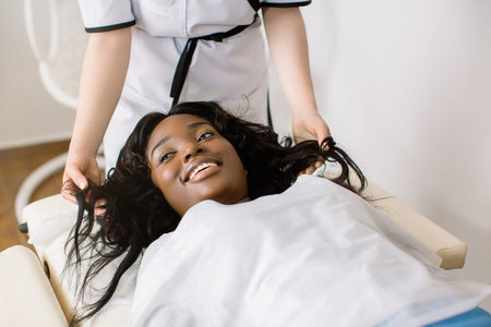 Cropped image of hands of female doctor cosmetologist trichologist dermatologist examining the state...