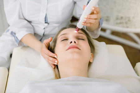 Cropped shot of pretty woman getting birthmark or vascular net removed by laser at beauty salon....