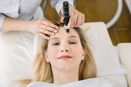 Dermatology and cosmetology clinic. Cropped top view of face of pretty blond woman during skin...