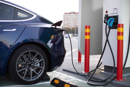 Eco car, electric transportaion concept. Electric car on charging station in front of city buildings