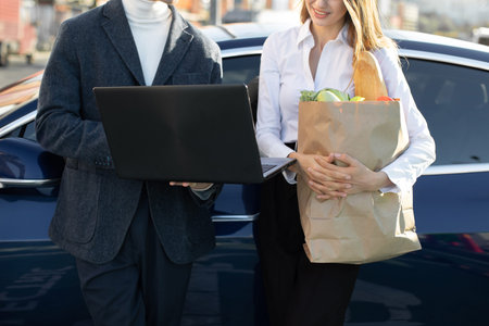 Close up cropped front view of busy modern people, man and woman, working on laptop pc, while...